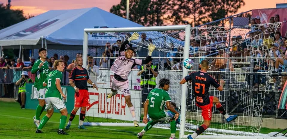 Goalkeeper attempting to save a shot in match