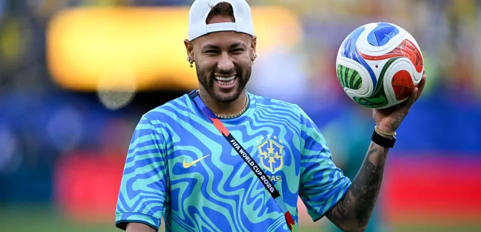 Player holding a soccer ball, smiling on field