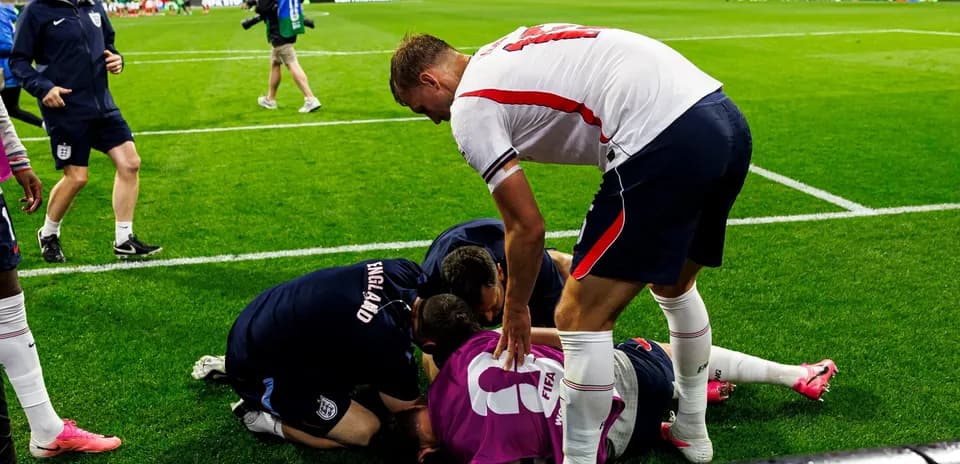 Players and staff attending to a downed goalkeeper