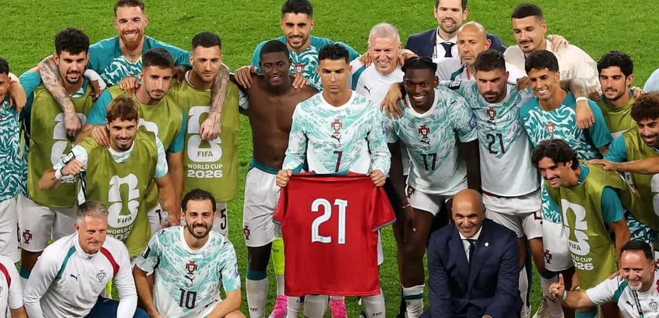 Portugal team celebrating with player holding jersey