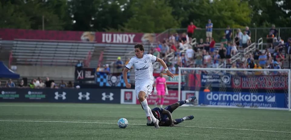 Player evades tackle during Rhode Island match