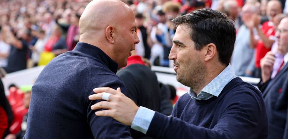 Two coaches greeting each other in the stands