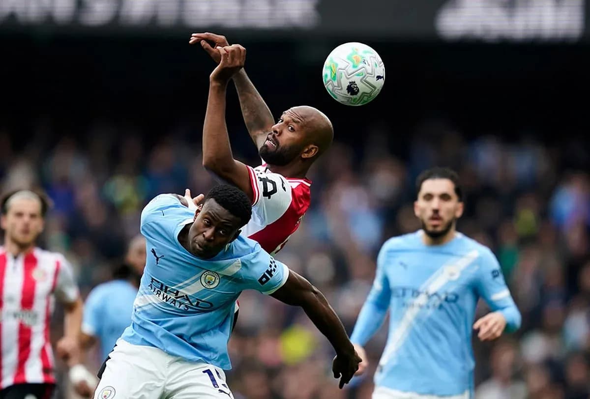 Manchester City player challenging Brentford opponent