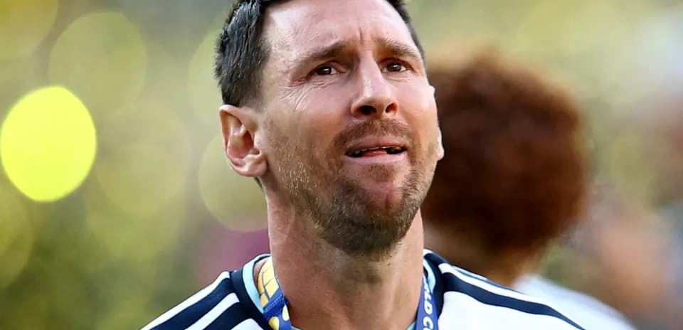 Player wearing Argentina jersey celebrating with medal