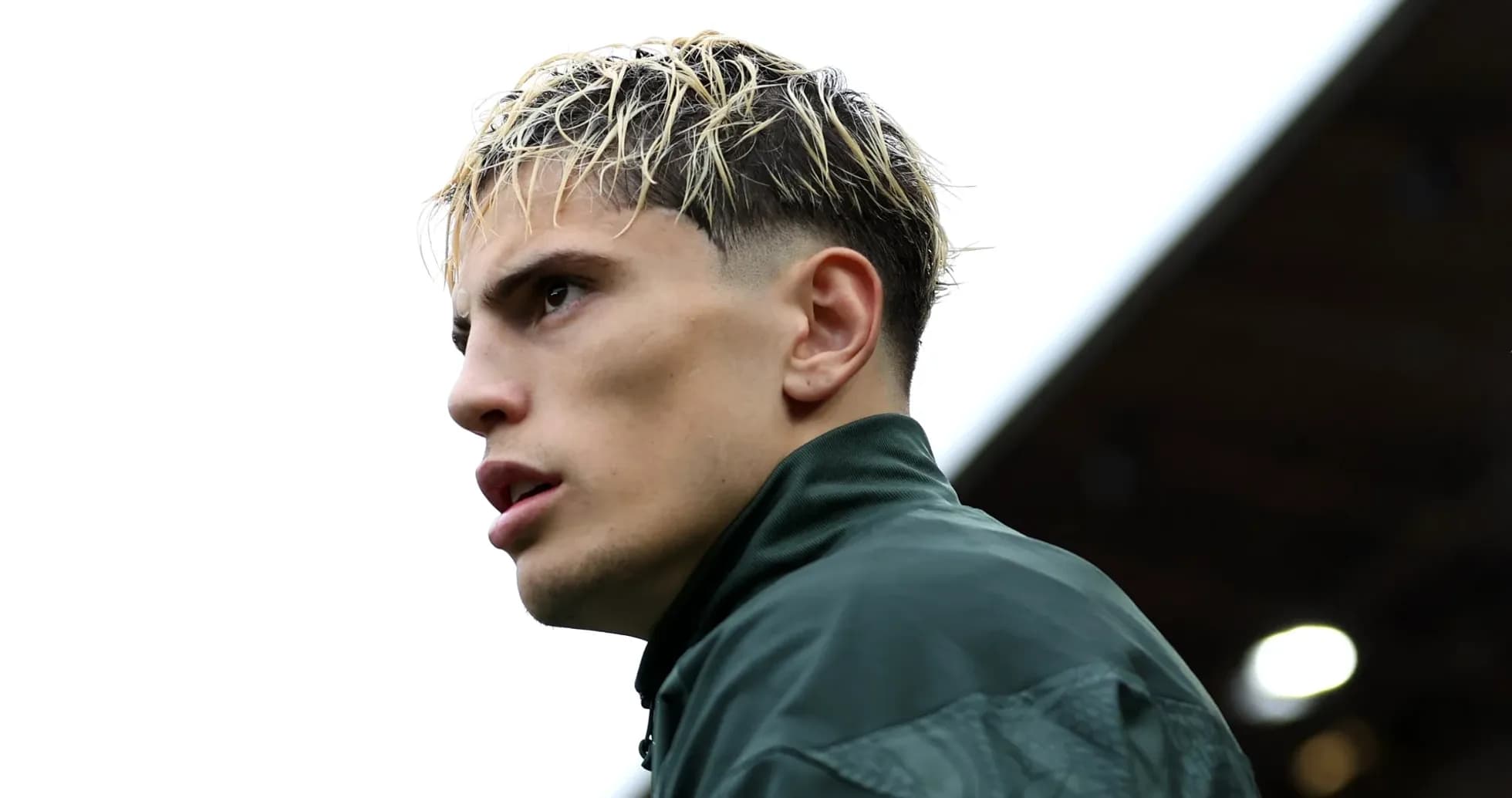 Player in green jacket looking off to side