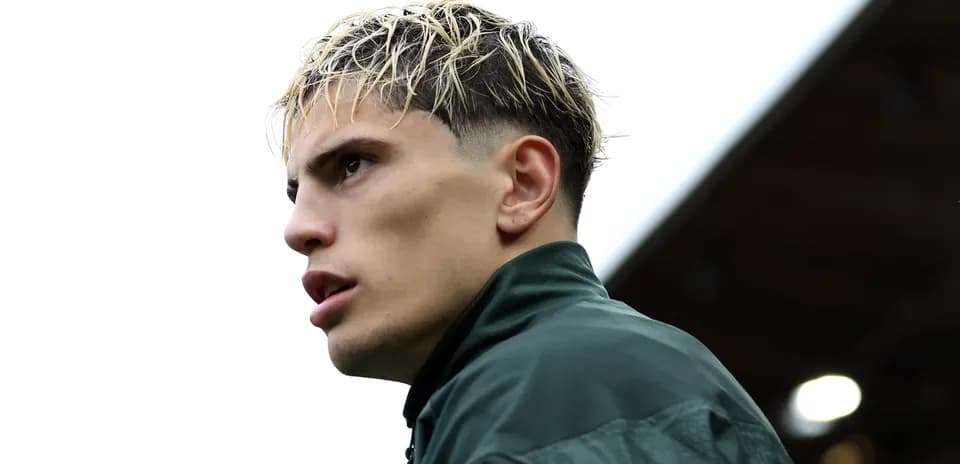 Player in green jacket looking off to side