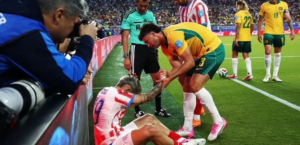 Player receiving assistance from teammates on sidelines