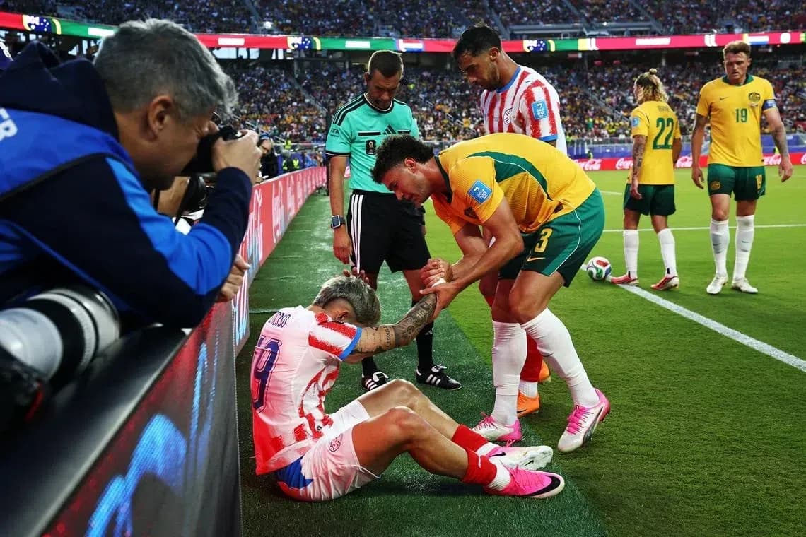 Player receiving assistance from teammates on sidelines