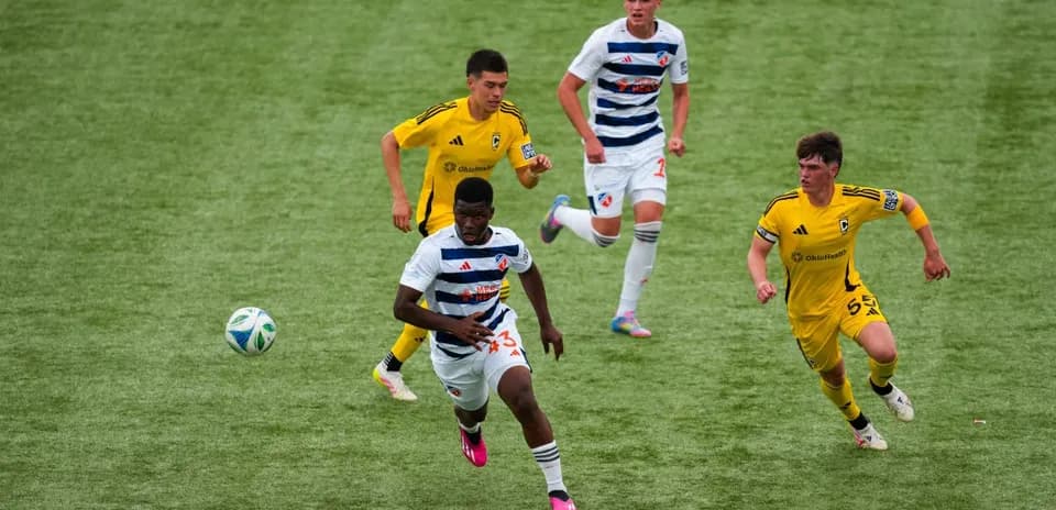 FC Cincinnati II player dribbling past Columbus Crew II opponents