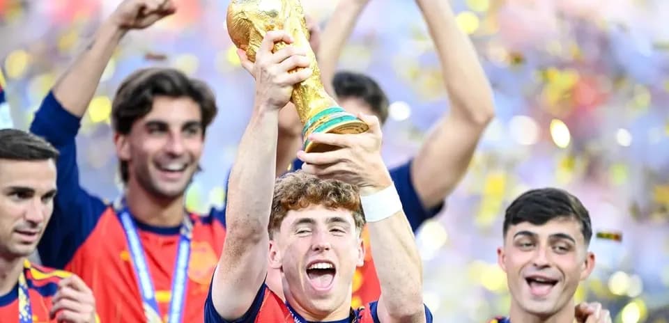 Player celebrating with World Cup trophy surrounded by teammates