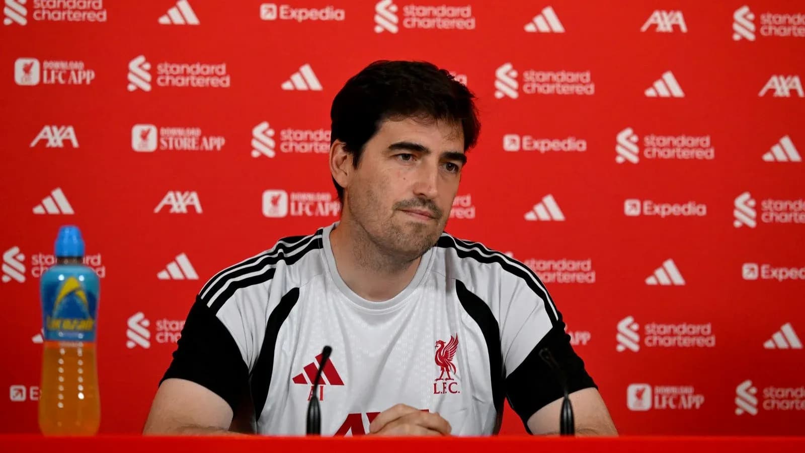 Manager at press conference with Liverpool branding