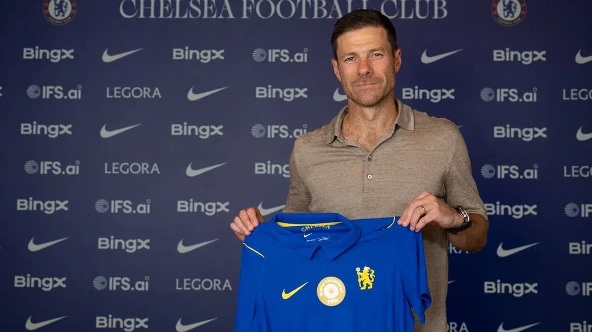 New coach holding Chelsea FC jersey at presentation