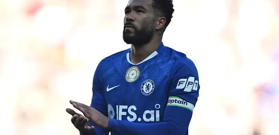 Player in blue jersey applauding crowd during match