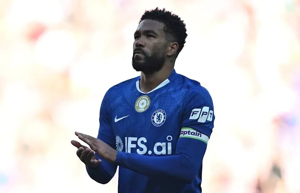 Player in blue jersey applauding crowd during match