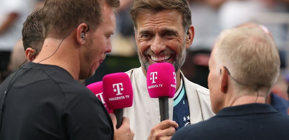 Four individuals holding microphones during an interview