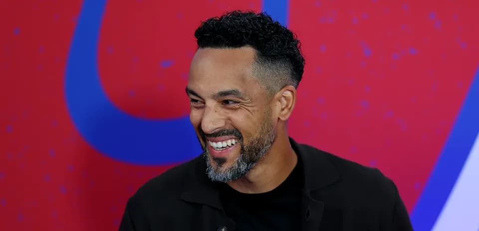 Man smiling in front of a colorful background