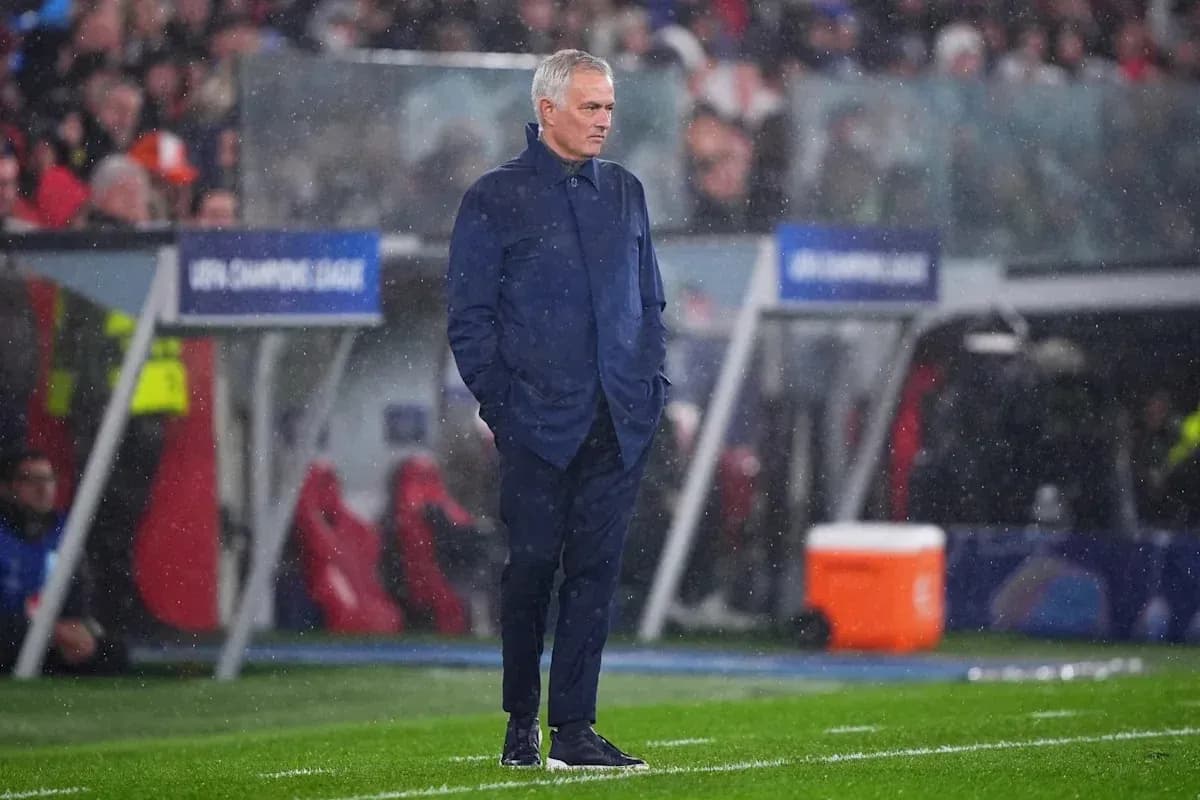 Coach standing on the sidelines during a rainy match