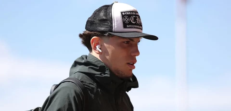 Player walking with headphones and cap outdoors