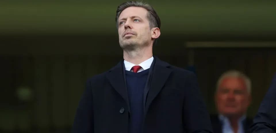 Man in suit observing from a stadium box