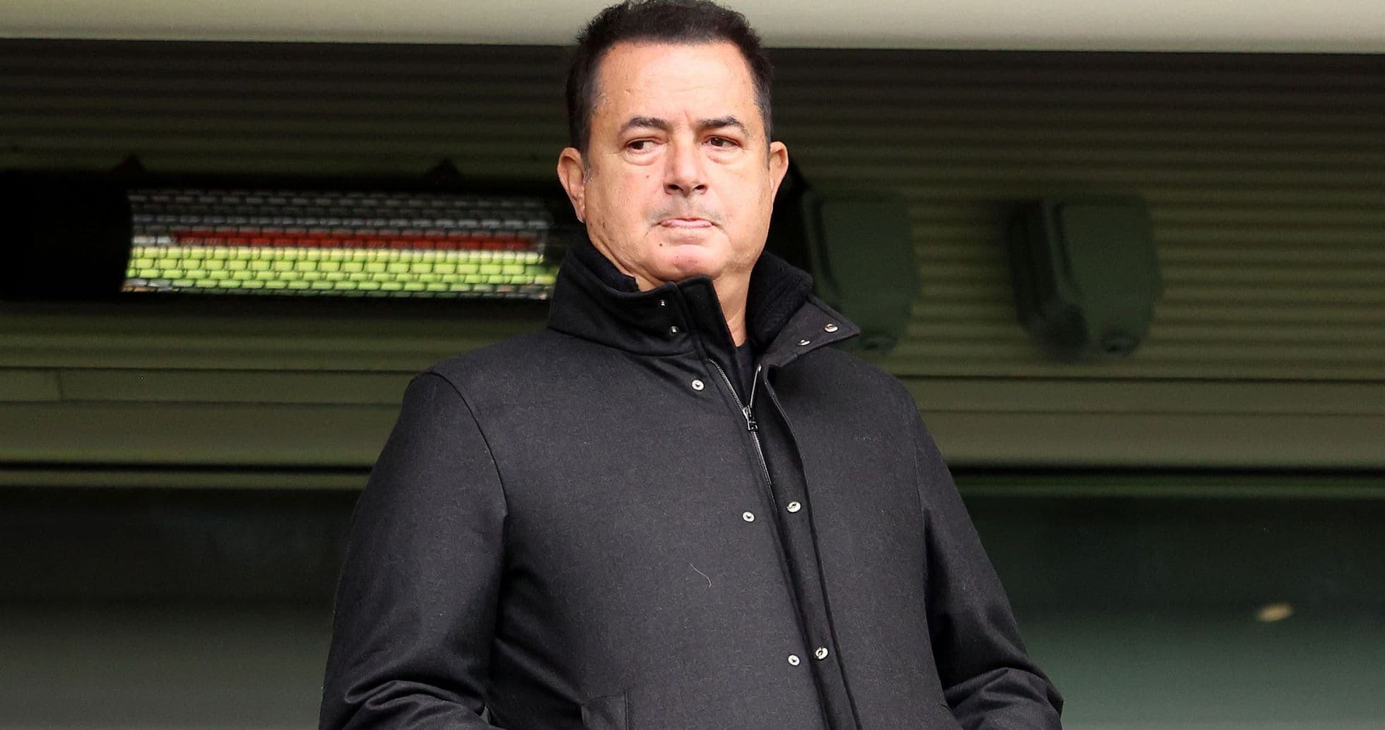 Man in black coat standing at stadium entrance