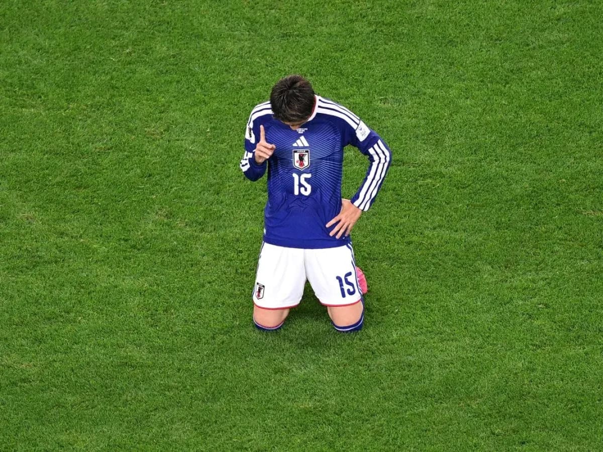 Japanese player kneeling on the pitch during match