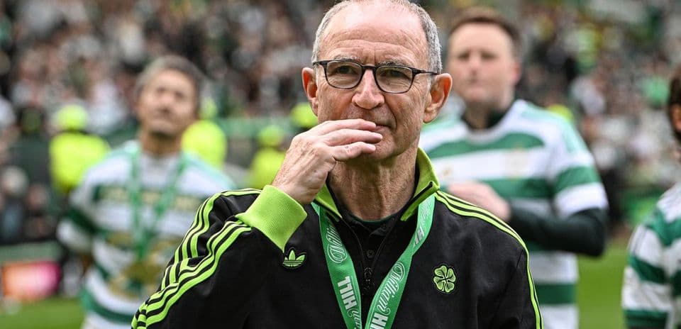 Manager walking on the pitch with team behind