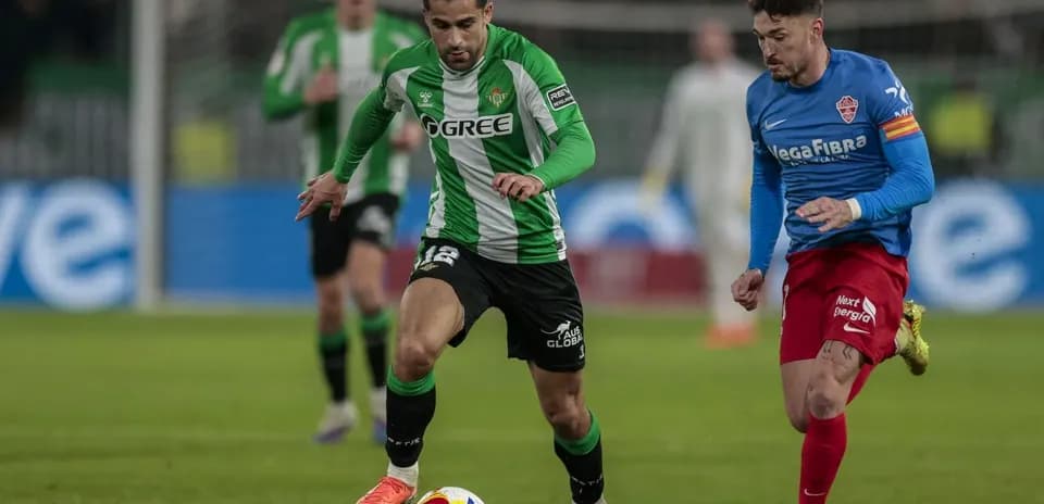 Real Betis player dribbling against Elche defender
