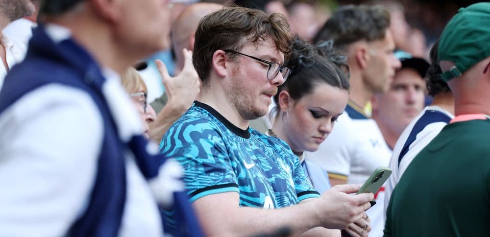 Fans focused on their phones during the match