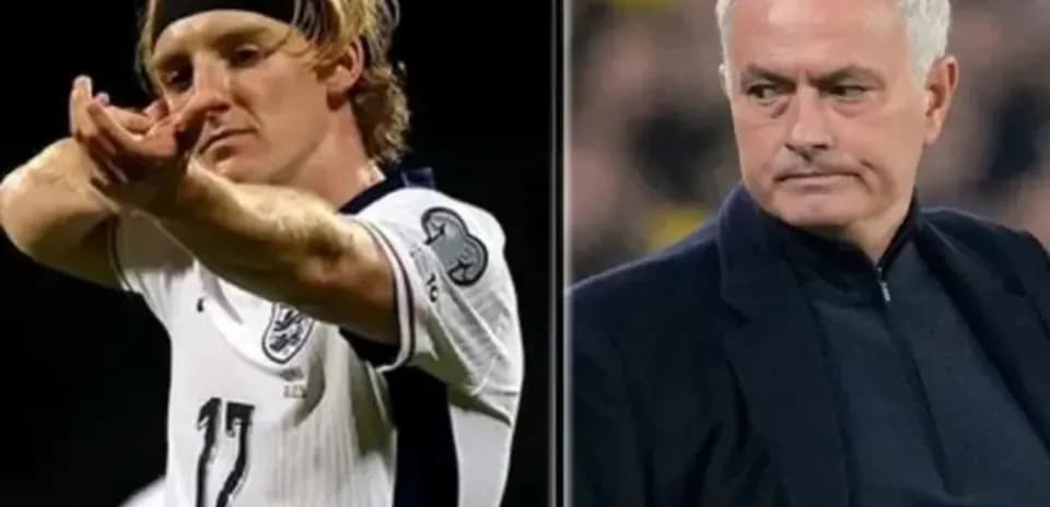 Player celebrating goal and manager observing match
