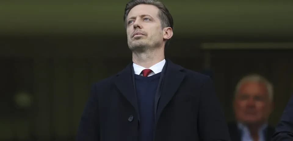 Man in formal attire observing from a stand