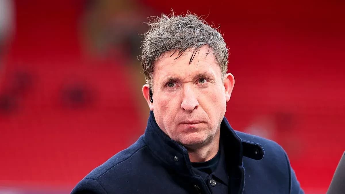 Man in coat with ear piece on stadium backdrop
