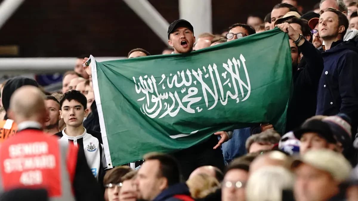 Fans holding Saudi Arabian flag in stadium