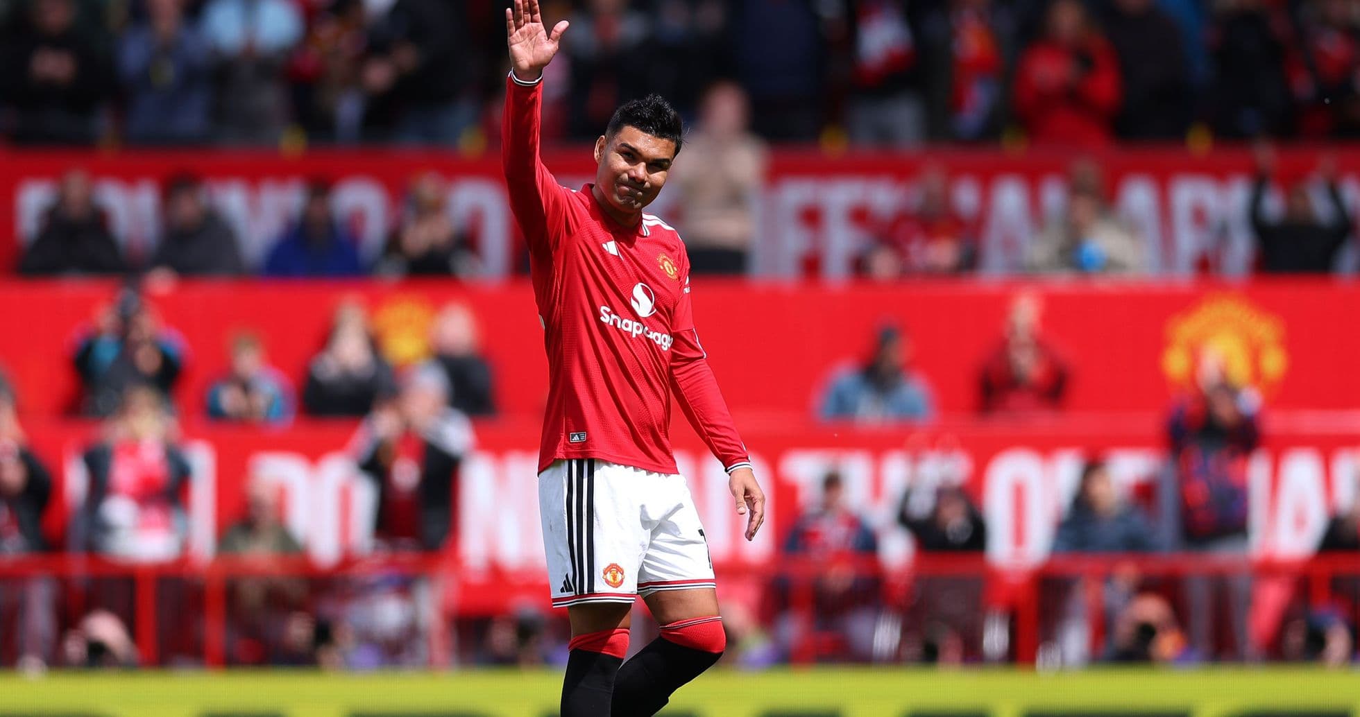 Player waving to fans during match at Old Trafford