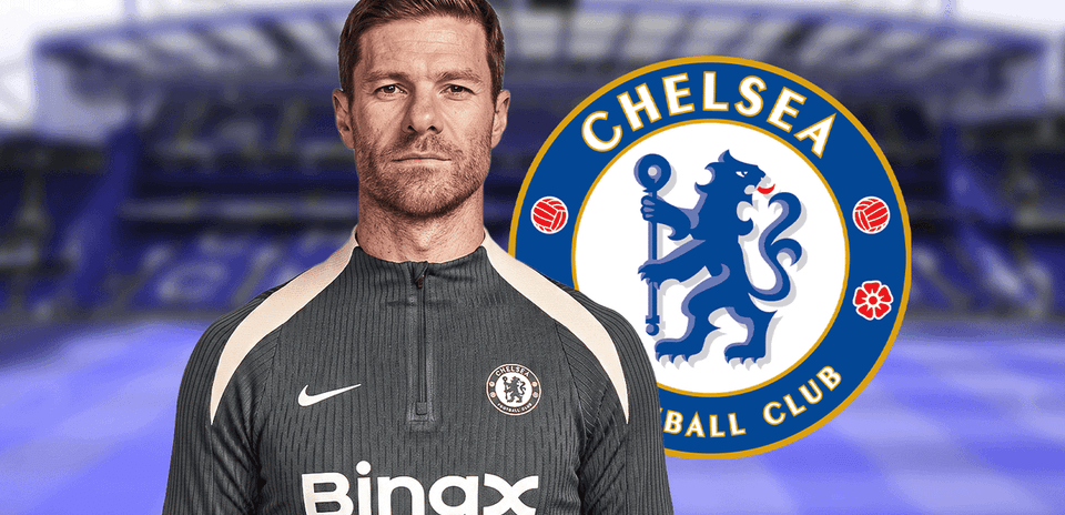 Coach in training gear with Chelsea logo backdrop