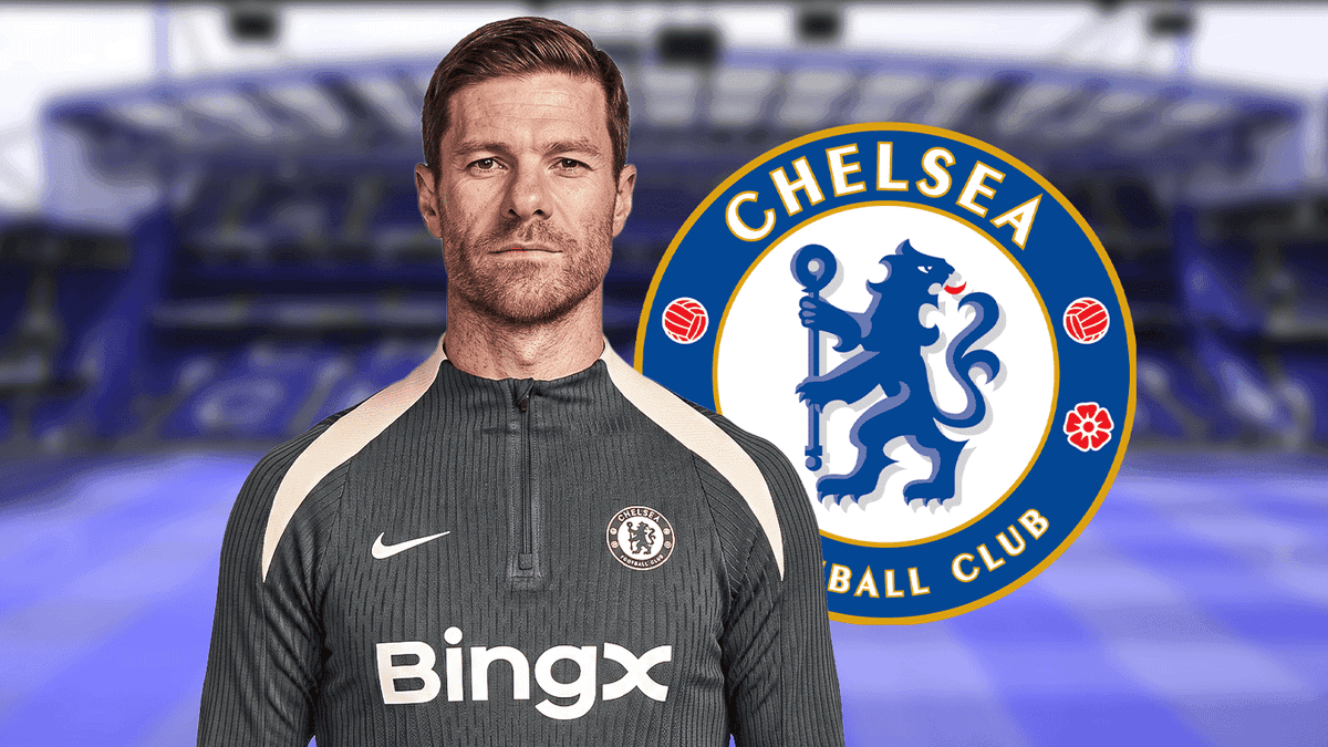 Coach in training gear with Chelsea logo backdrop