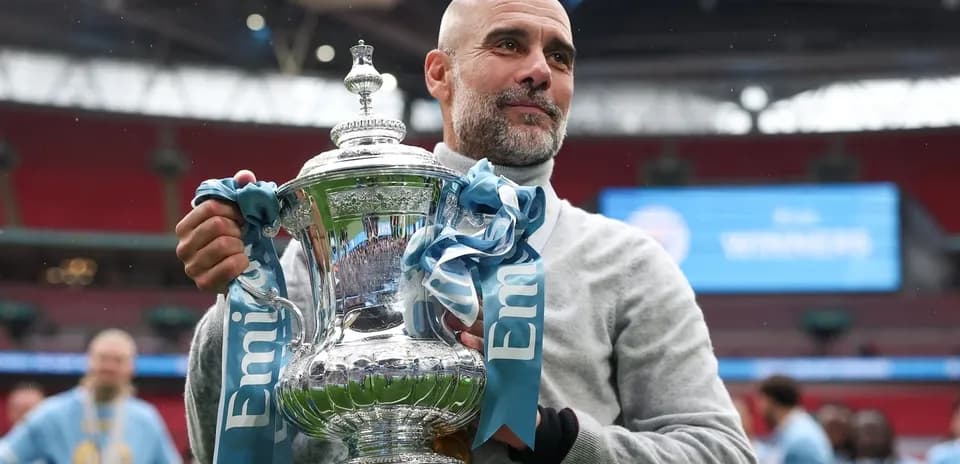 Manager holding trophy after cup final victory