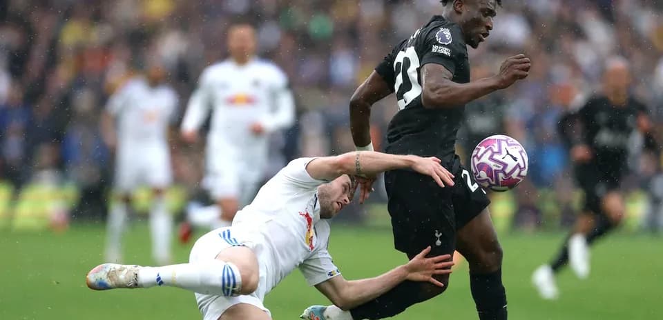 Player dribbling the ball while opponent falls behind