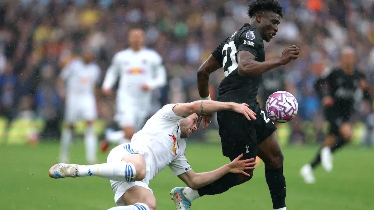 Player dribbling the ball while opponent falls behind