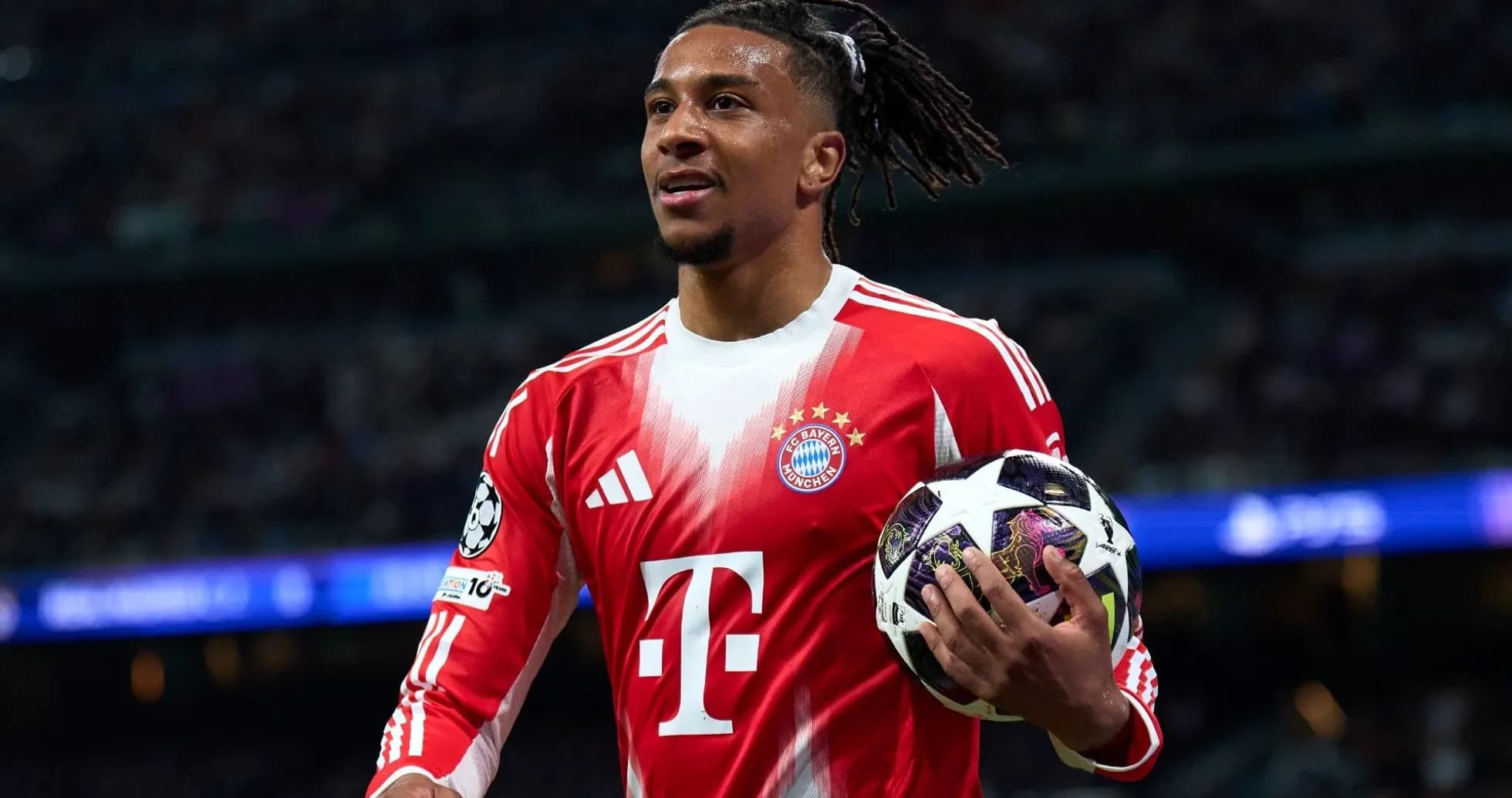 Player holding a UEFA Champions League ball on field