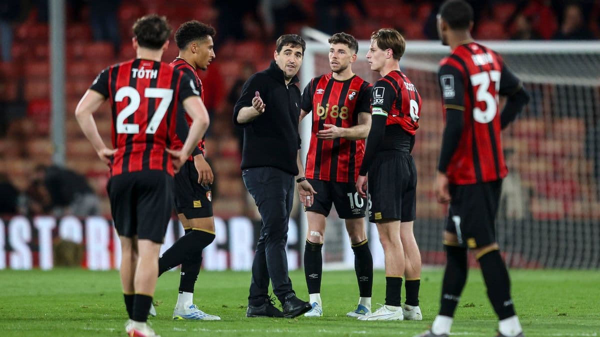 Coach discussing strategy with Bournemouth players on field