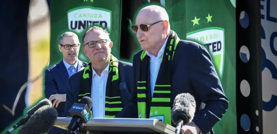 Officials at Canberra United press conference with microphones