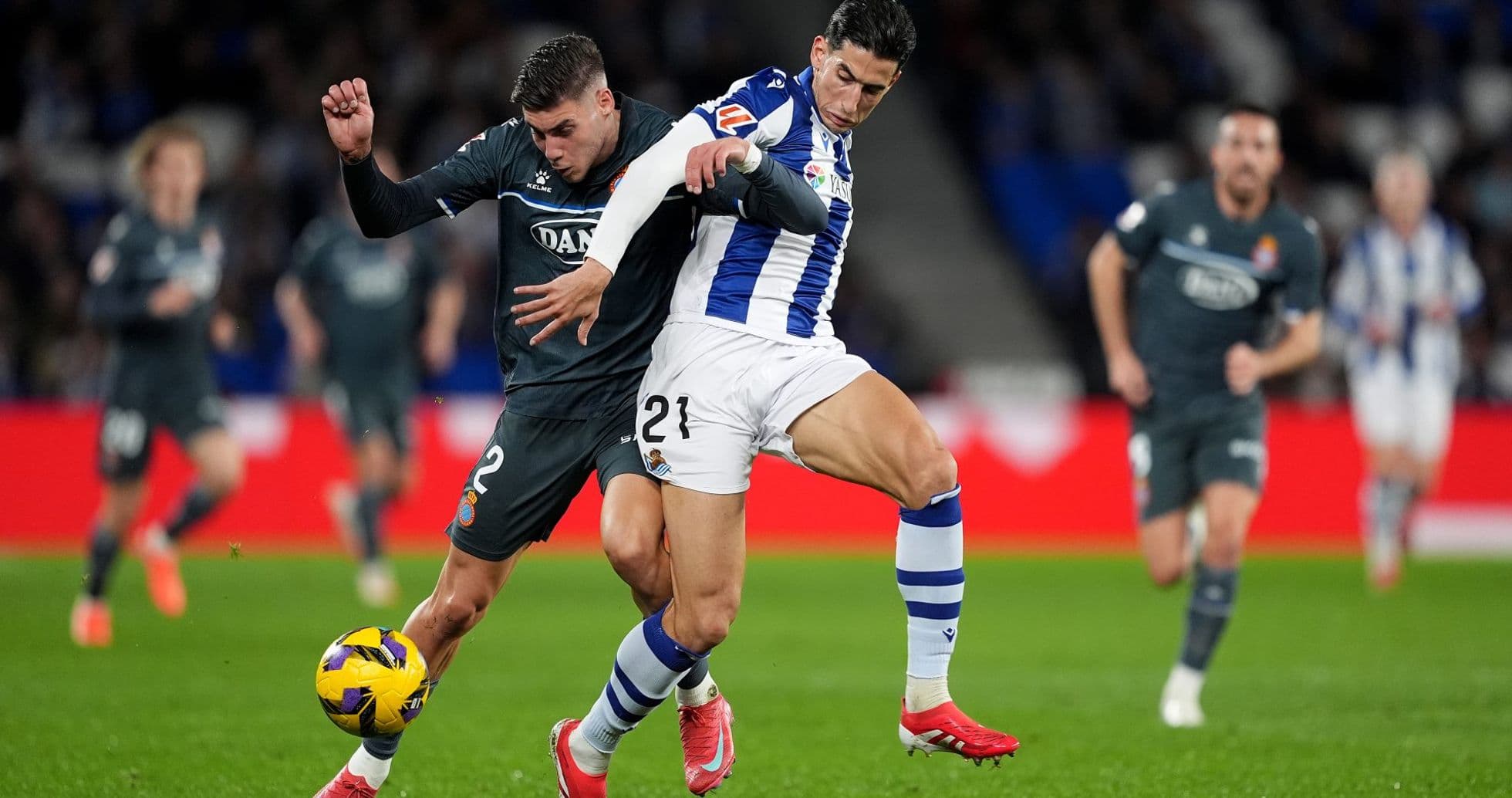 Espanyol player tackling Real Sociedad opponent