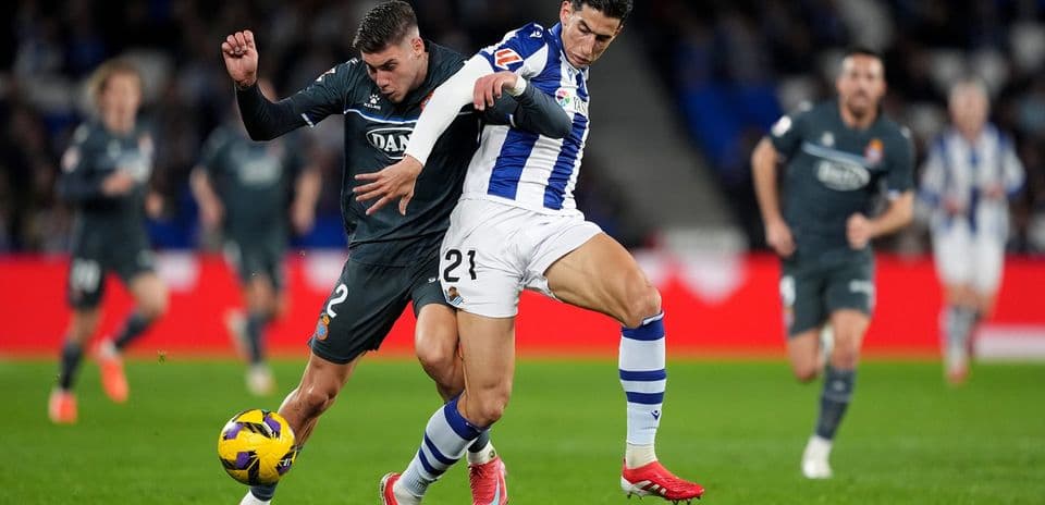 Espanyol player tackling Real Sociedad opponent