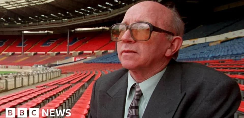 Man sitting in empty stadium with red seats