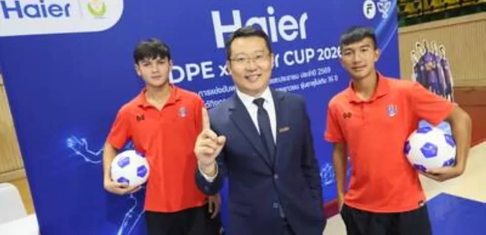 Two young players with a businessman and soccer balls