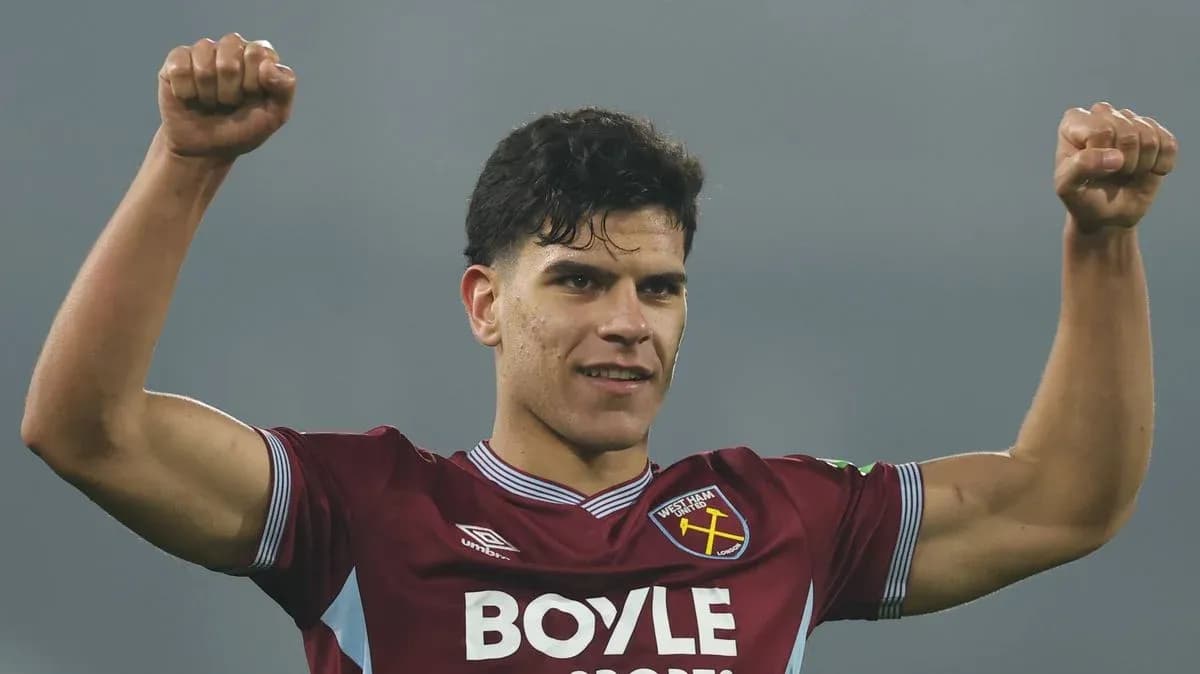 Player celebrating with raised fists in team jersey
