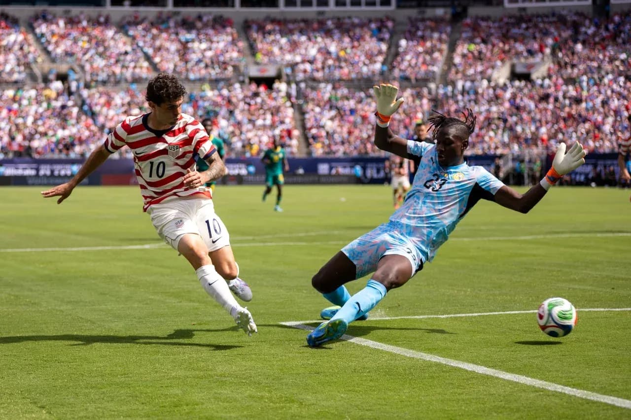 USA player attempting to score against Paraguay goalkeeper USA player attempting to score against Paraguay goalkeeper