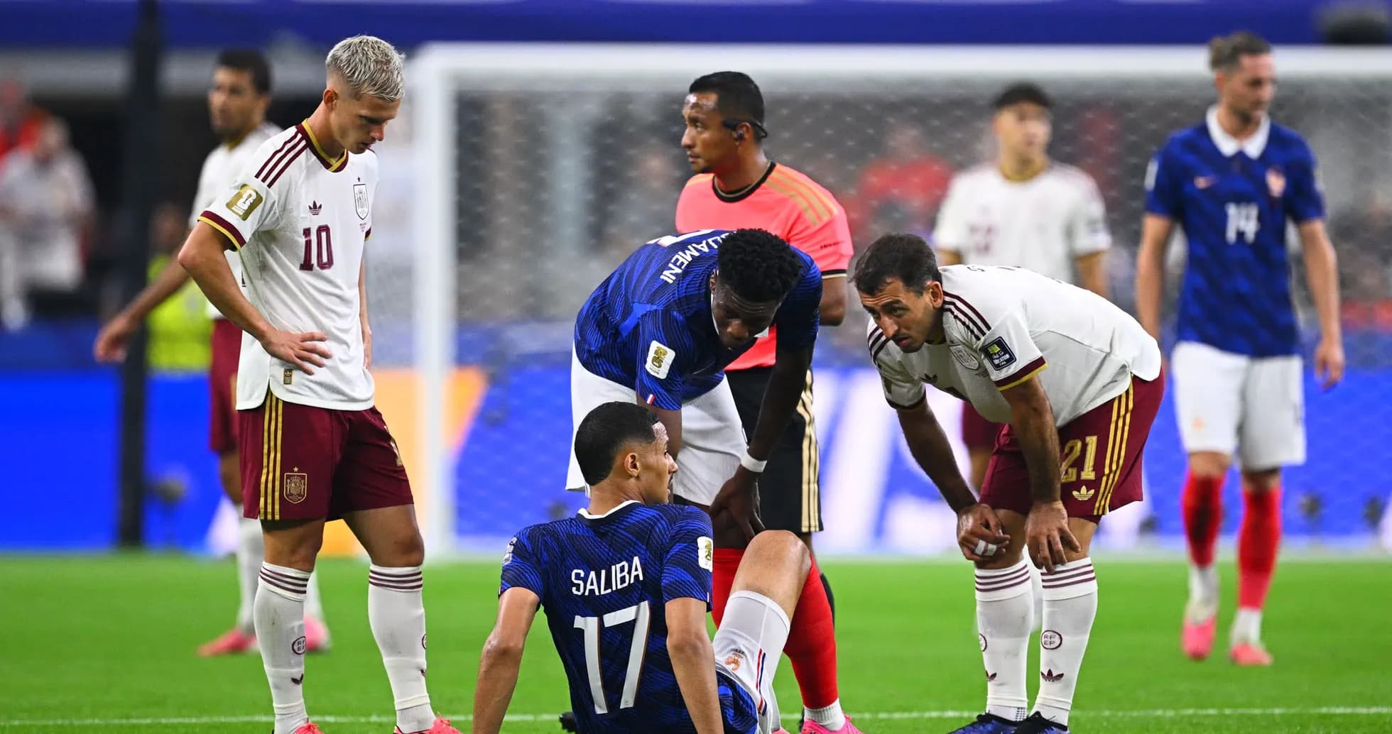 Players attending to injured player on the field Players attending to injured player on the field