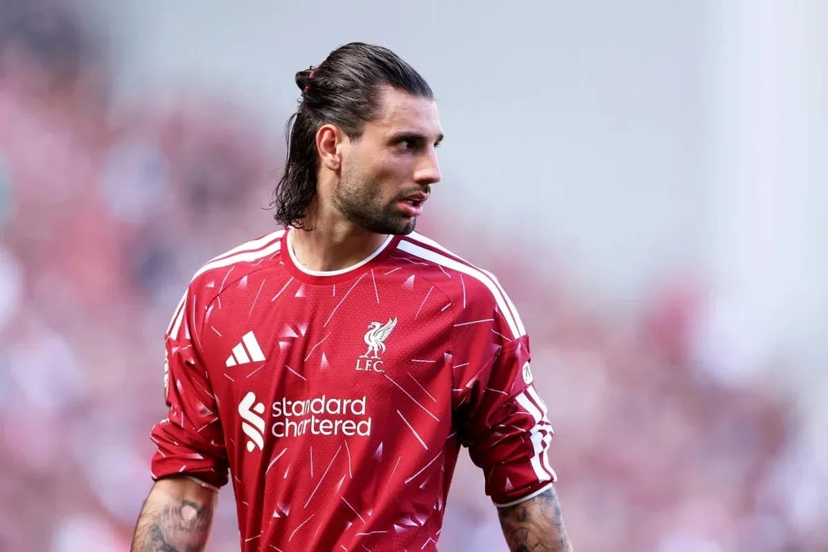 Goalkeeper in red Liverpool jersey on field Goalkeeper in red Liverpool jersey on field