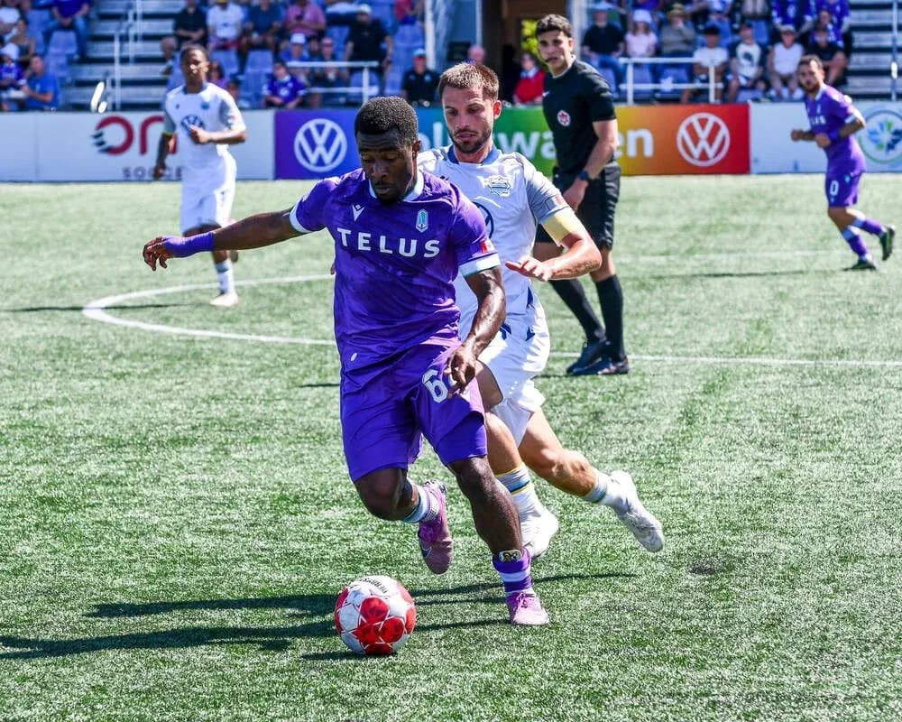 Pacific FC player dribbling past HFX Wanderers player Pacific FC player dribbling past HFX Wanderers player